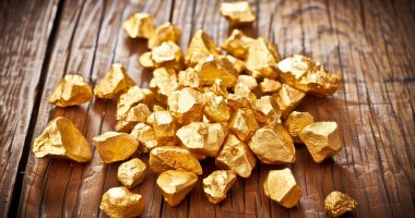 An image of gold nuggets on a wood floor.