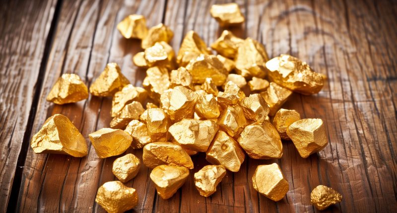 An image of gold nuggets on a wood floor.