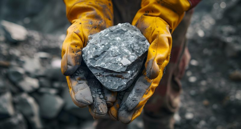 Image of a man holding lithium rocks.