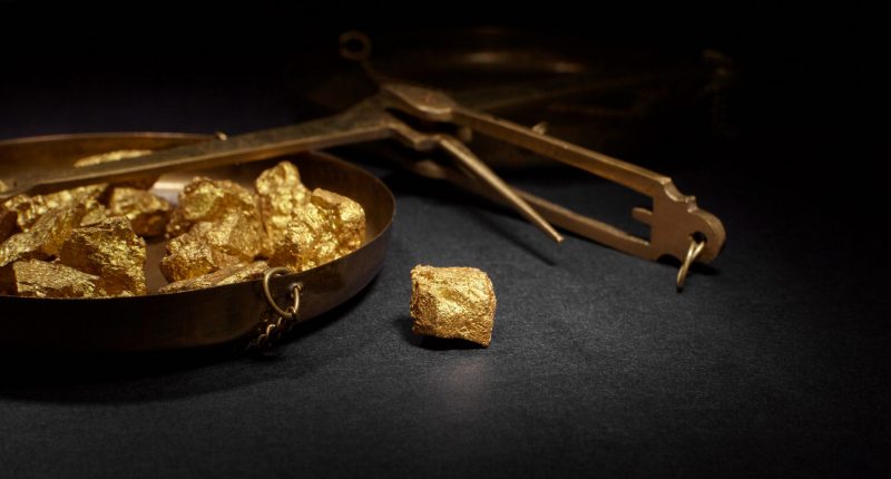 Closeup image of gold nuggets and a copper scale