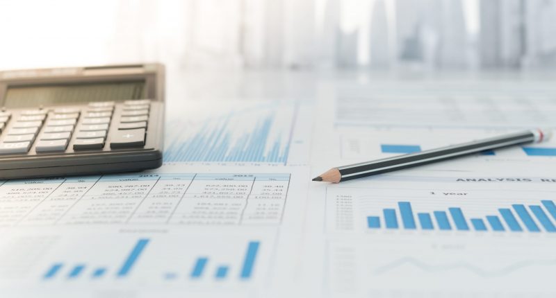 Pencil, calculator with financial chart and graph report on table of business consultant. Concept of invest planning, analyze return on investment.