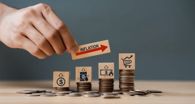 Hand putting wooden cube and inflation word a on coins