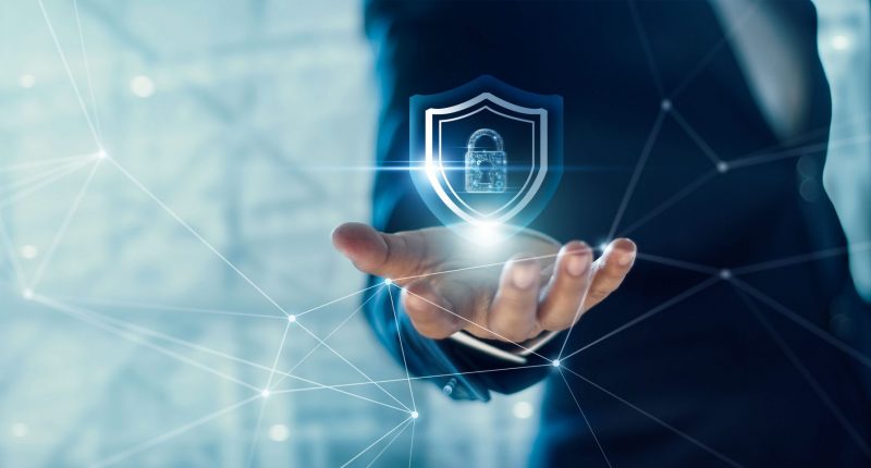 Businessman holding Shield with padlock in hand on global networking