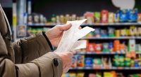 Image of a man checking prices on a receipt