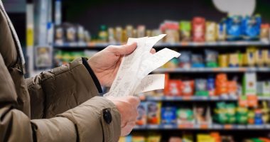 Image of a man checking prices on a receipt