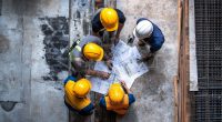 Group of men in hard hats planning a project