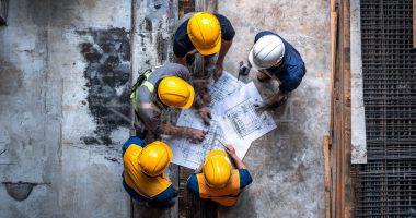 Group of men in hard hats planning a project