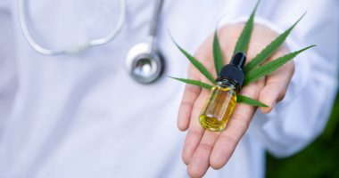 Image of a woman holding a bottle of hemp oil