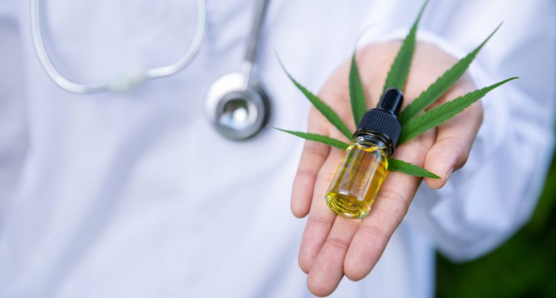 Image of a woman holding a bottle of hemp oil