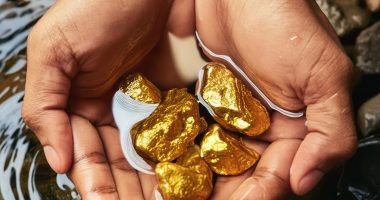 Image of a person holding gold nuggets