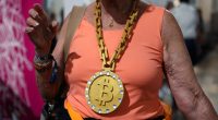 A woman wearing a BitCoin gold medal.