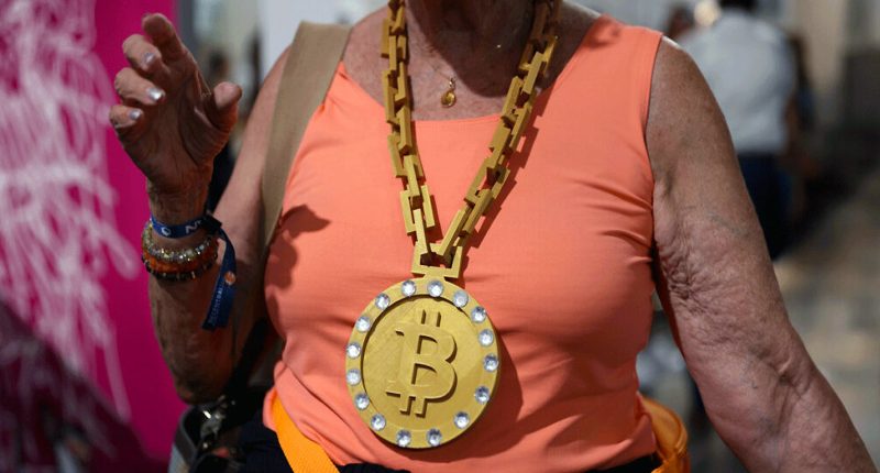 A woman wearing a BitCoin gold medal.