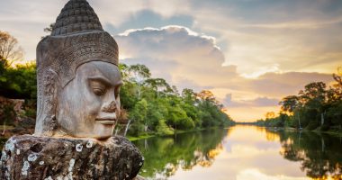 Stone face Asura on causeway near South Gate of Angkor Thom in Siem Reap in Cambodia