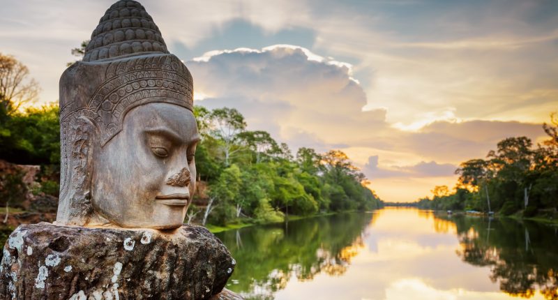 Stone face Asura on causeway near South Gate of Angkor Thom in Siem Reap in Cambodia