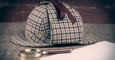 Image of a deerstalker hat and magnifying glass