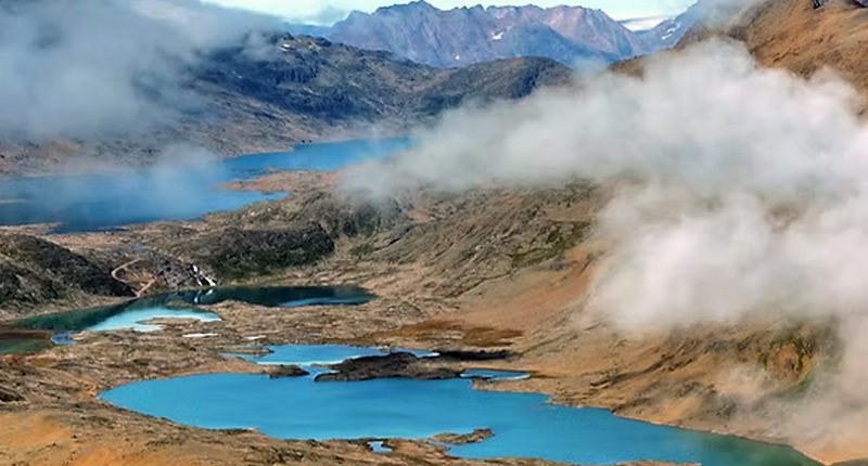 The Blue Lagoon project as seen by above. A blue lithium lake stretches between cloud-covered mountains.