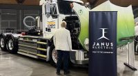 A man looks up at a Janus Electric EV truck at the Everything Electric roadshow.