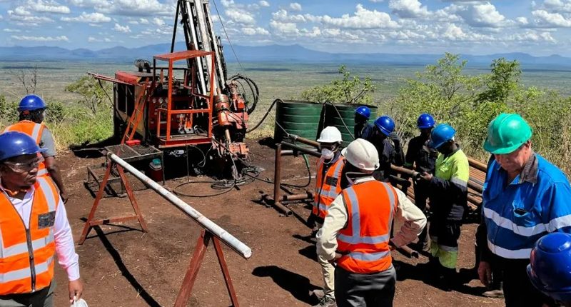 Lindian Resources workers in safety gear survey a Malawi work site