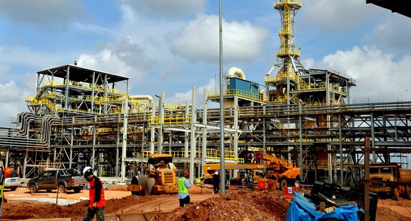 A Lynas Rare Earths critical minerals production facility. It has yellow trims and there's workers all over the structures.