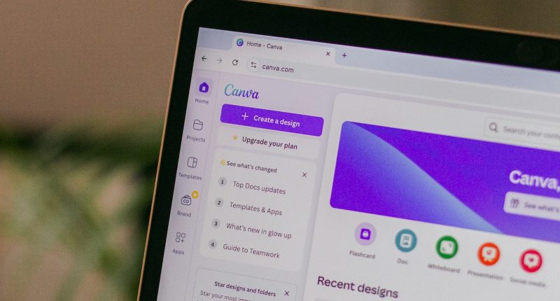 The side of an Apple laptop with the Canva website open on the browser page.