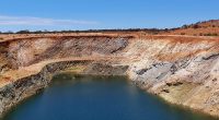 A blue lake surrounded by brown chalky rock banks.