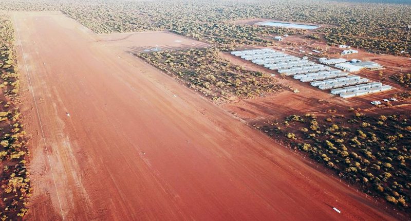 The Dalgaranga mine's entrance road. There are several silos off to the side of the red road.