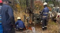 Haranga Resources workers check on an RC drilling rig at Ibel South.