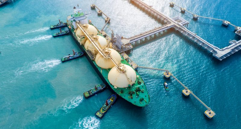 LNG (Liquefied natural gas) tanker anchored in Gas terminal gas tanks for storage. Oil Crude Gas Tanker Ship. LPG at Tanker Bay Petroleum Chemical or Methane freighter export import transportation