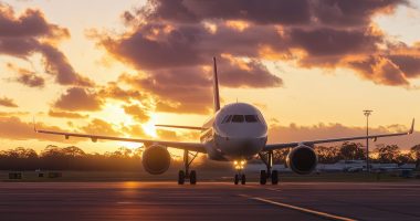 airplane parked at the airport in the Australian countryside, with a beautiful sky and clouds, golden hour lighting